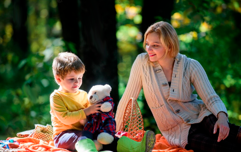 Happy son with mother relax in autumn forest sunny weather healthy food mother love small child spring mood happy family day family picnic mothers day spring